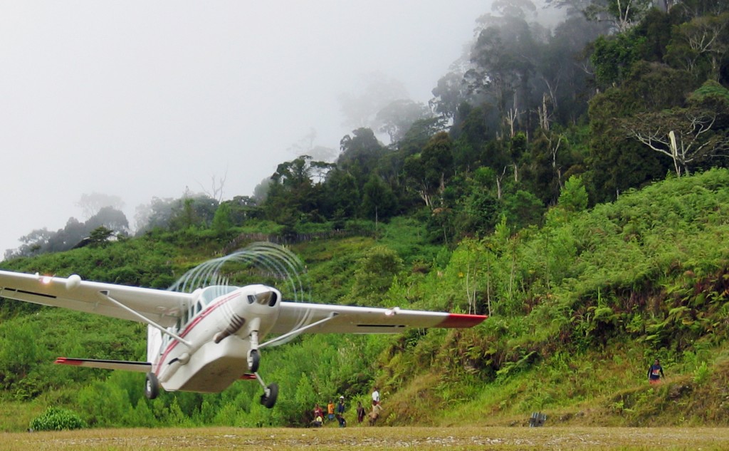 Propeller of plane taking off from jungle airstrip leaves spiraling condensation trail