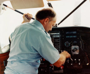 Avionics tech installing radios in a C-206 panel