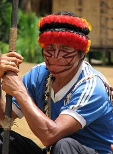 A Shuar man in the Amazon Jungle wears his own culture's coat