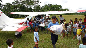 A Cessna 206 on a grass strip in the Amazon Jungle reveals differences in a peoples culture's coat